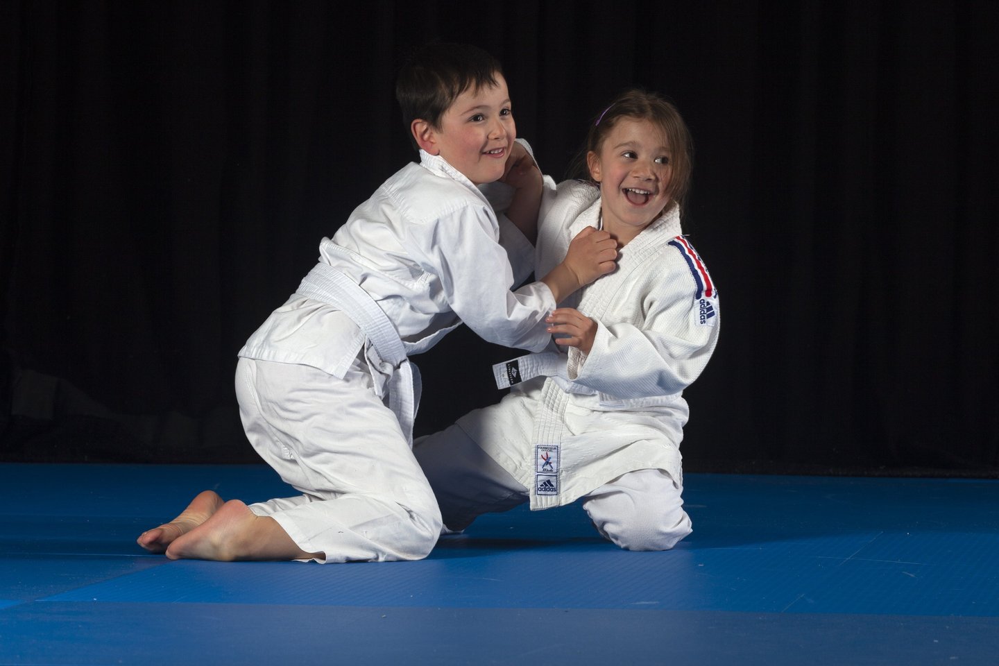 Jeunes judokas en cours de combat au sol sur un tatami