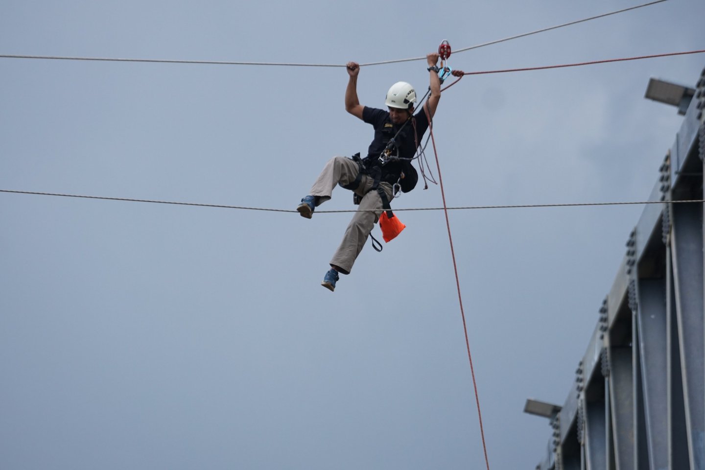 Professional technician performing high-altitude rope access work on a bridge structure.
