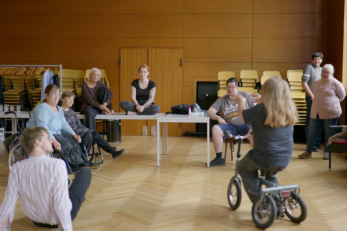 Menschen mit und ohne Behinderung unterhalten sich in einem Saal