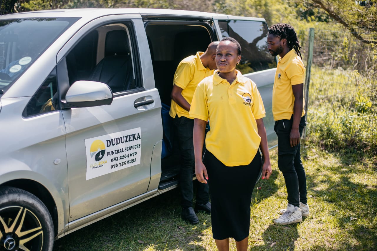 Duduzeka Funeral Services staff in yellow uniforms by their professional transport van.
