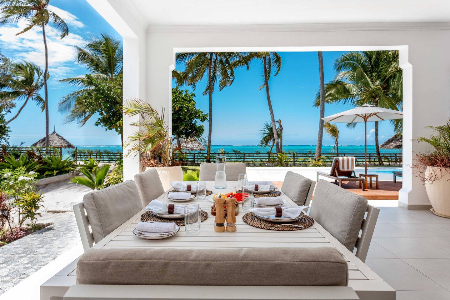 a table setting eight with a ocean view at Villa Serene Zanzibar