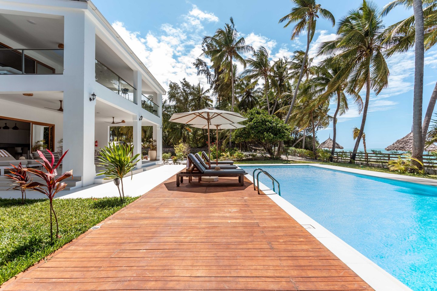 a wooden deck with lounge chairs and umbrellas