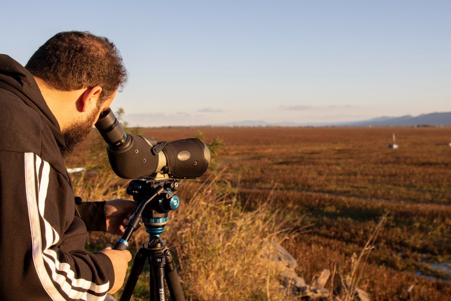 a man in a black jacket and a camera on a tripod