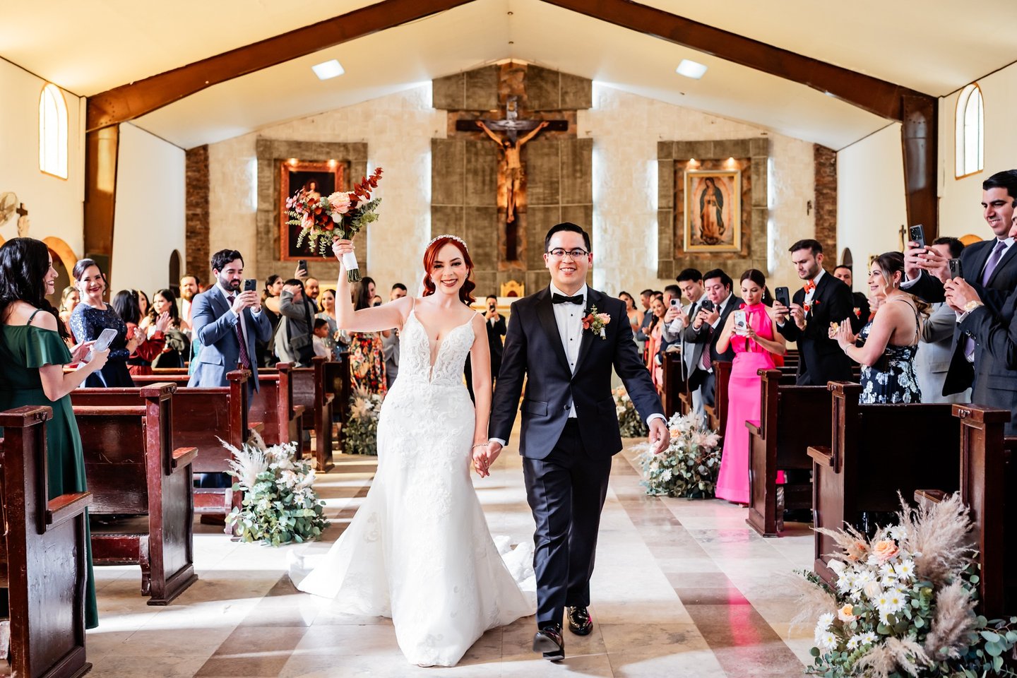 a bride and groom walking down the aisle of a church