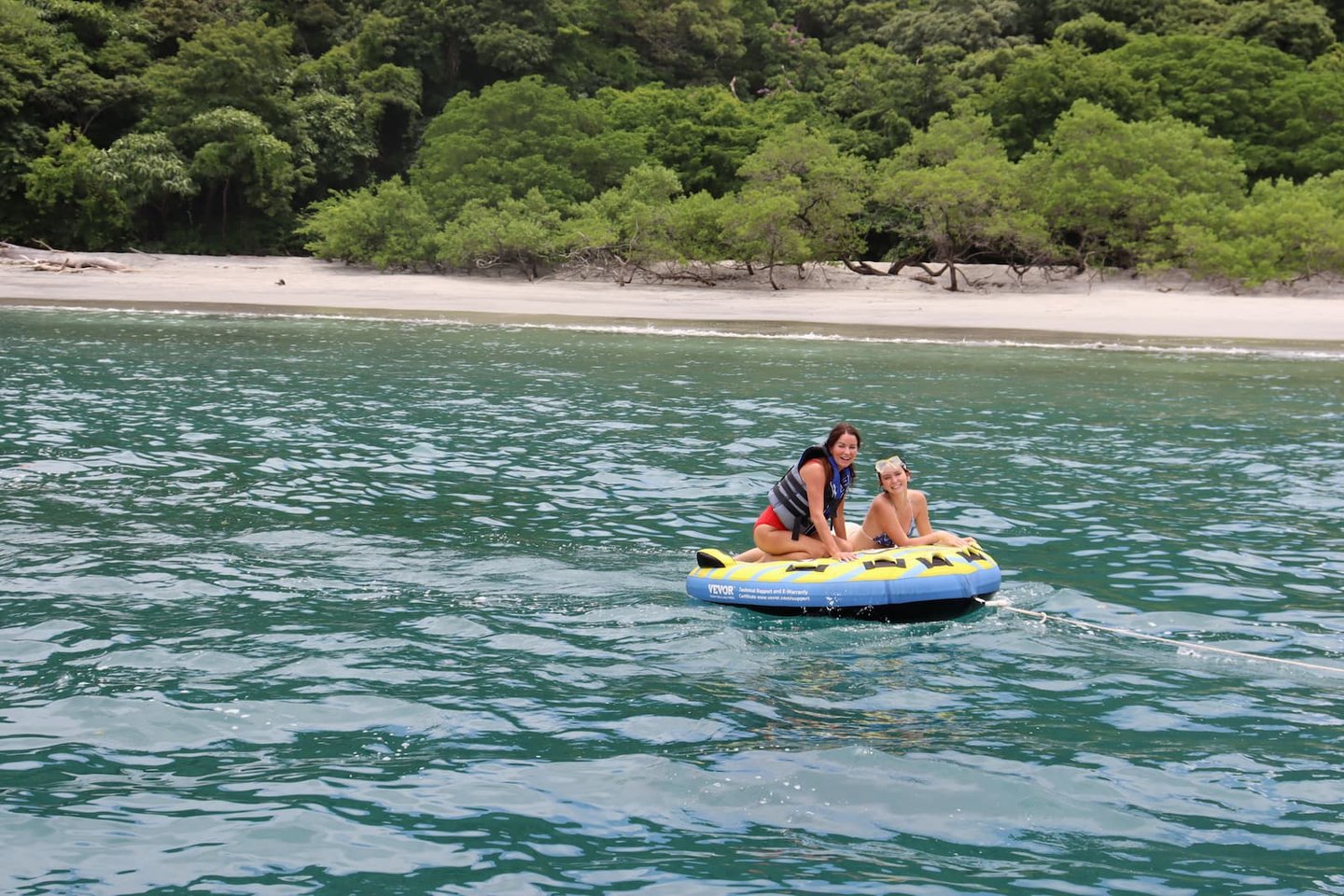 Friends tubing in turquoise waters during catamaran tour in Papagayo Gulf