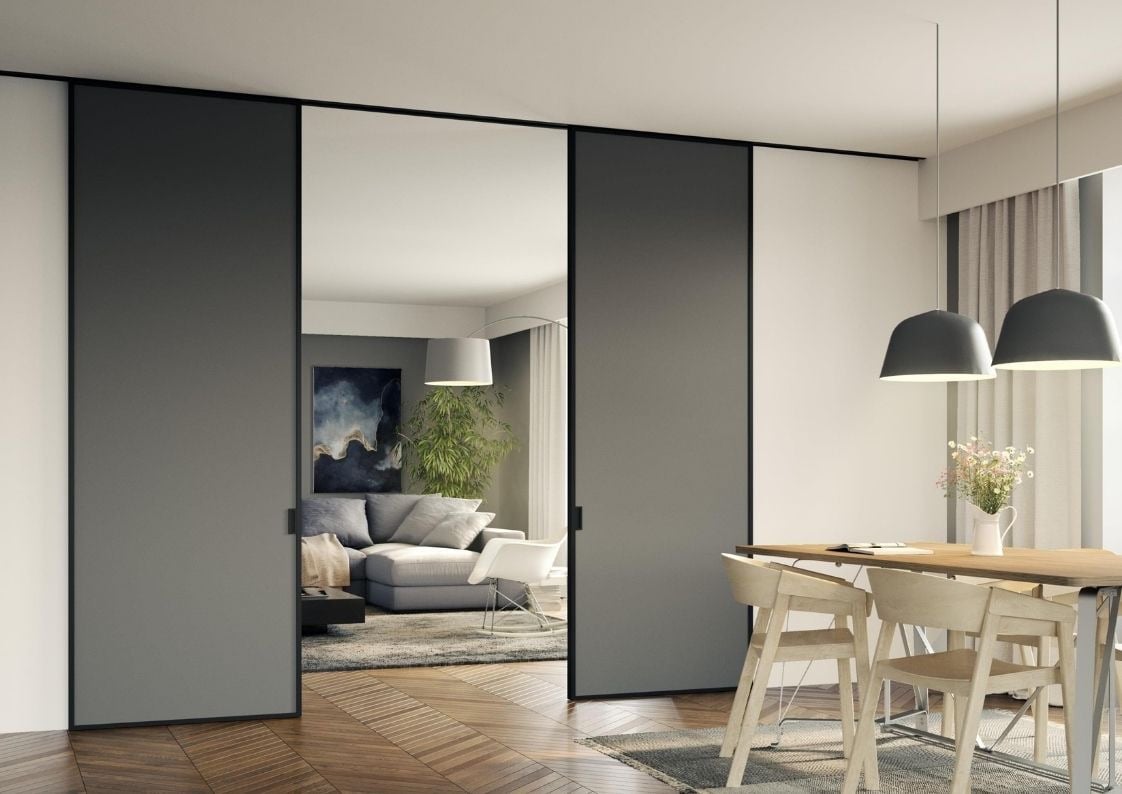 Puerta corredera acristalada con marco negro separando cocina y salón con diseño escandinavo
