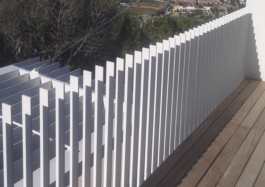 Detalle de valla blanca de aluminio con líneas horizontales para exterior de vivienda moderna