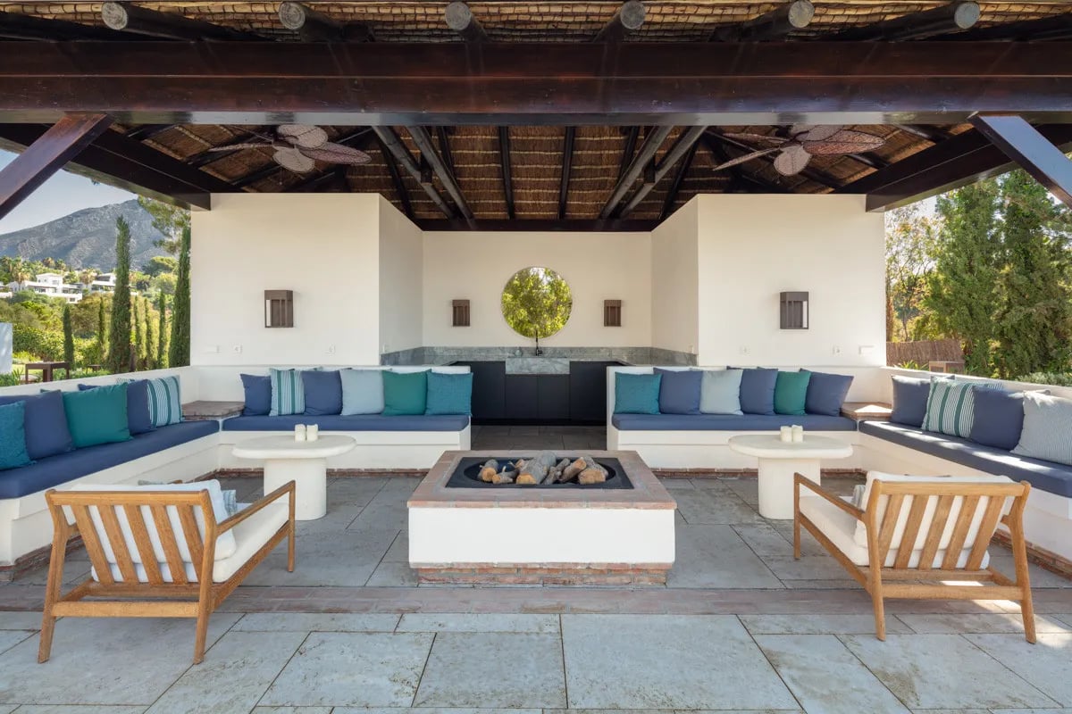 Covered outdoor lounge at Villa La Gratitud with fire pit and pool views