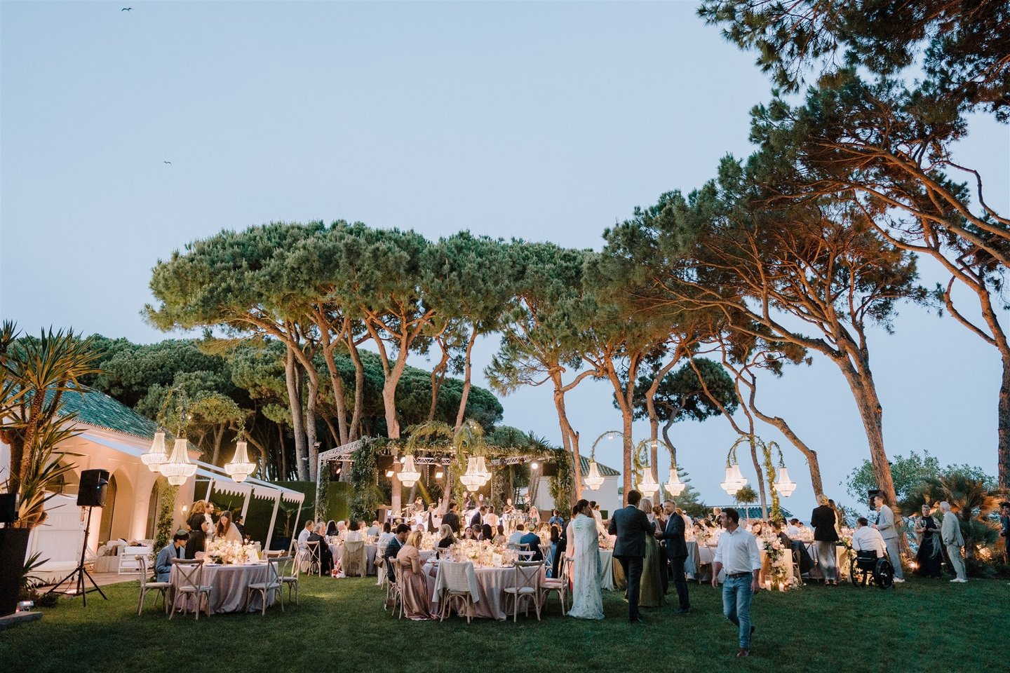 Evening wedding reception at Villa El Rincon with chandeliers and garden dining