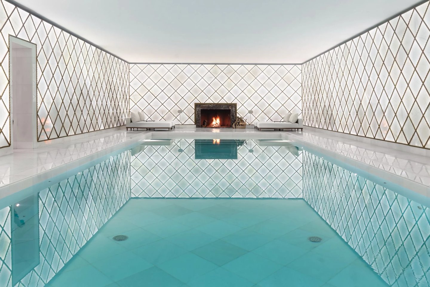 Indoor spa pool with fireplace and tiled walls