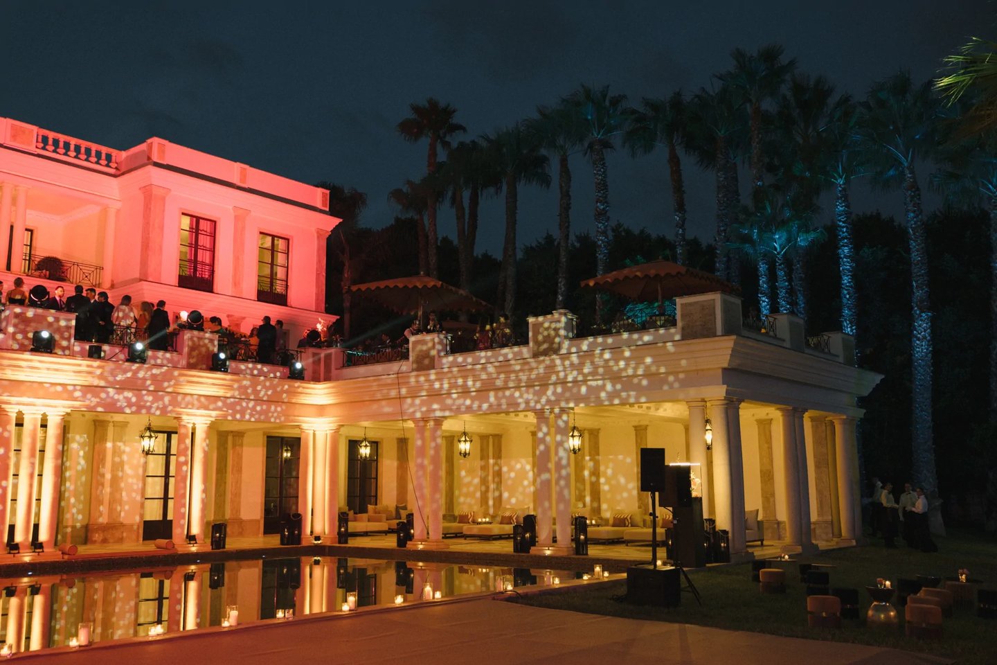 Grand villa façade illuminated in red at night