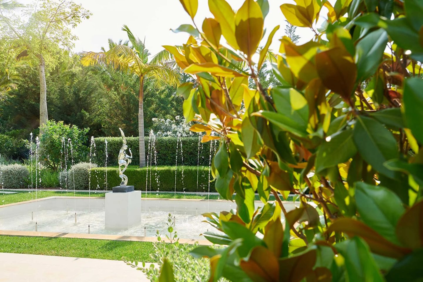 Elegant silver sculpture centers a multi-jet garden water feature