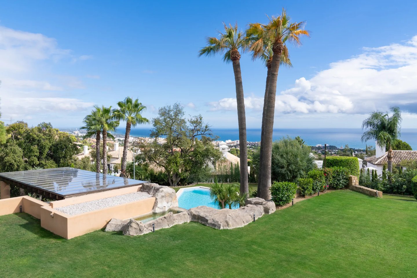 Garden pool with sea views and palm trees