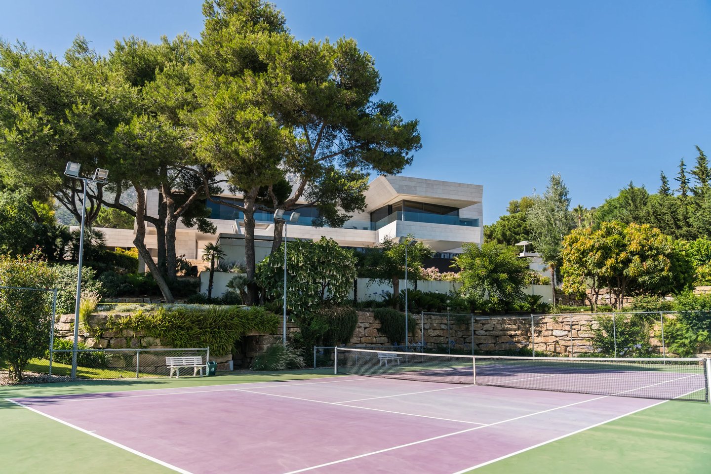 Private tennis court within landscaped gardens