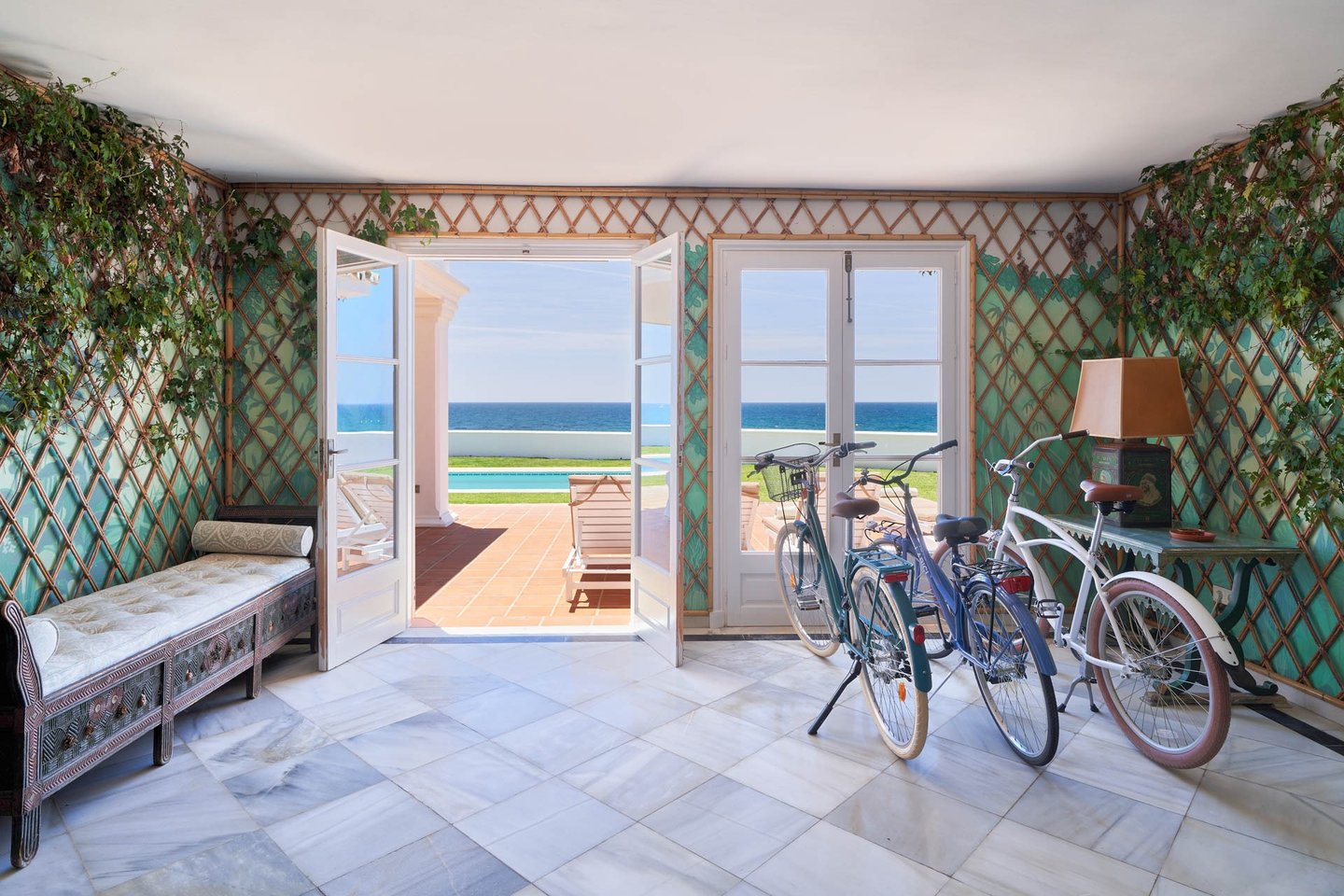 Sea-view lounge with bicycles and open terrace doors