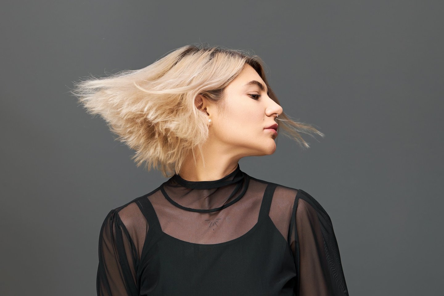 a woman with blonde hair and a black top