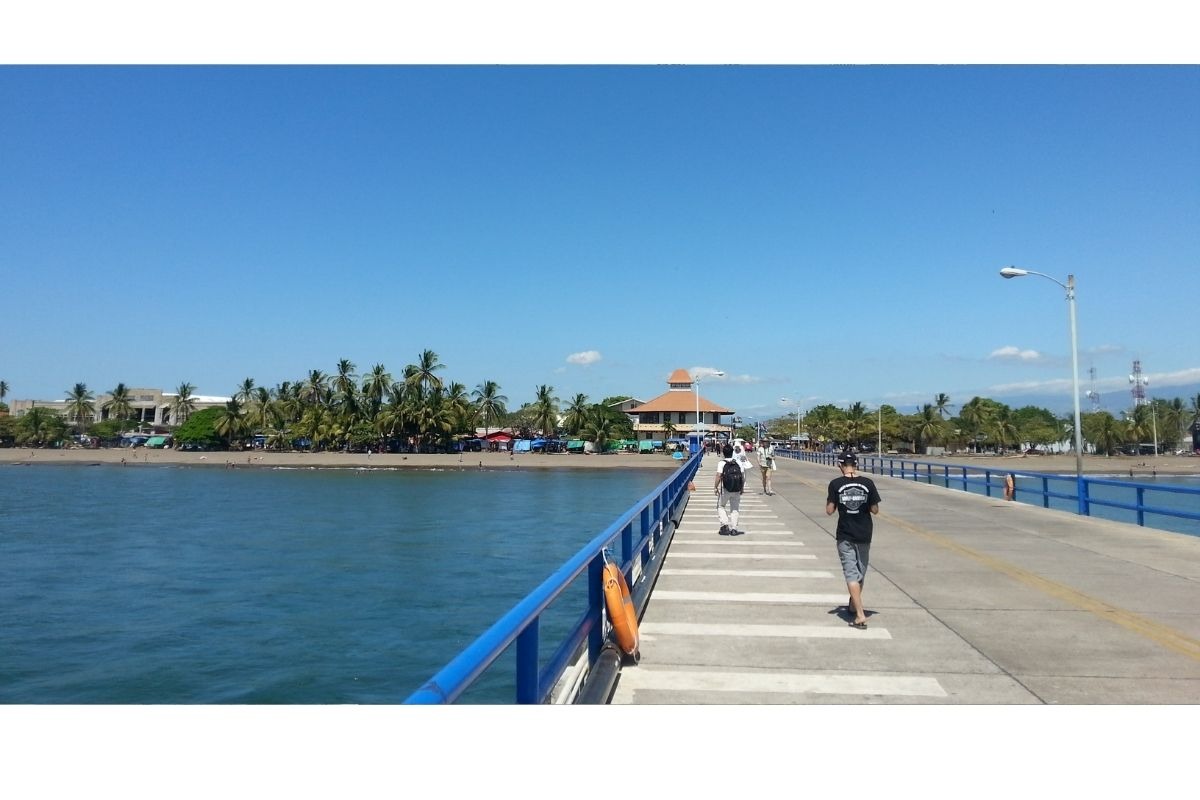 Vista do navio ancorado em Puntarenas, Costa Rica, com pier e cidade ao fundo