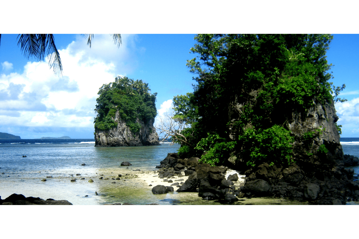 Vista panorâmica do Fatu-ma-Futi, o icônico cartão-postal de Pago Pago, Samoa Americana, com o mar azul e penhascos verdes ao