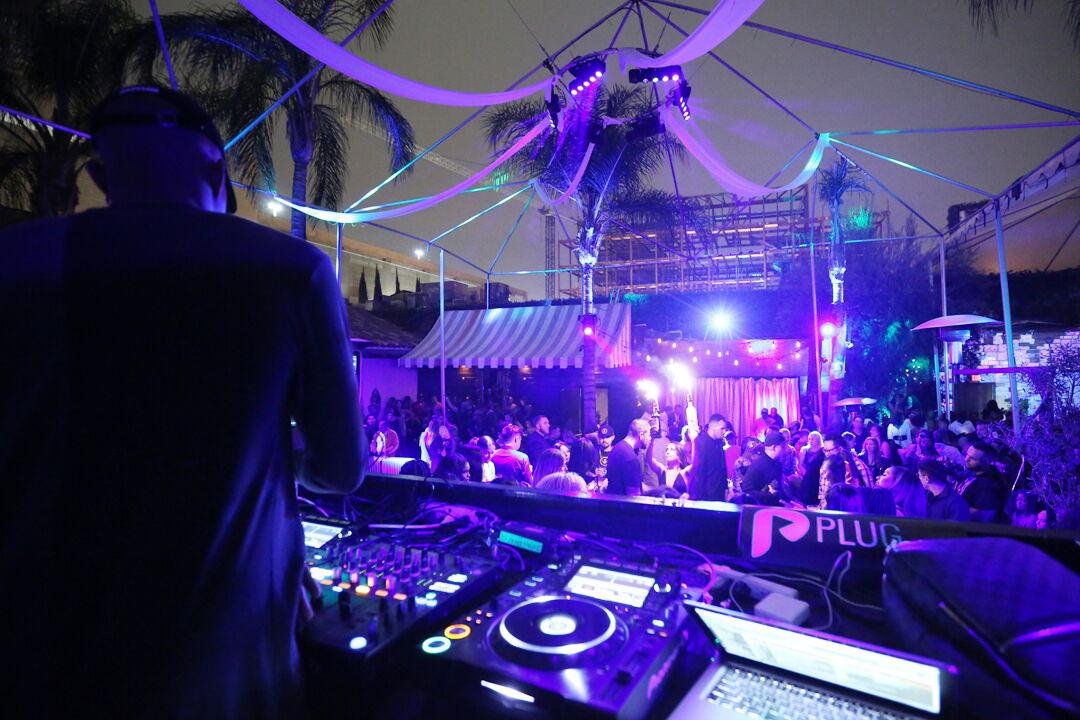 DJ Set with Purple Lights at Outdoor Club with Palm Trees
