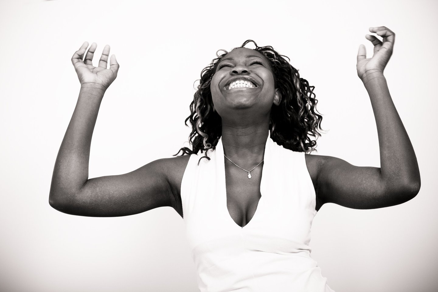 Femme qui rit et lève les mains au ciel