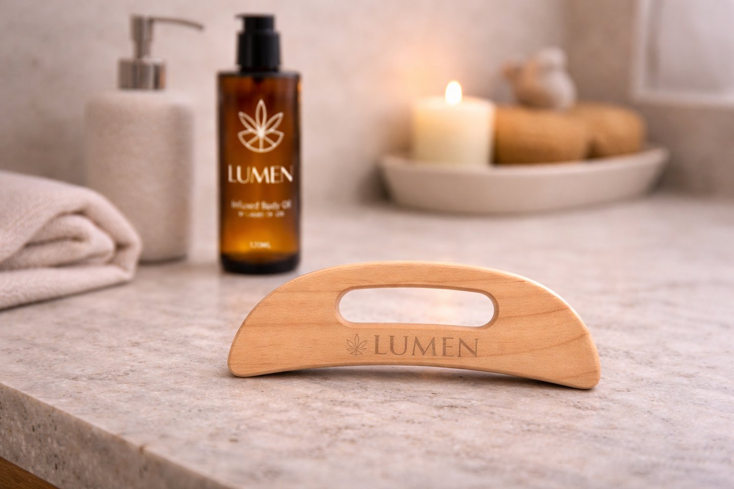Wooden gua sha massage tool and Lumen infused body oil on a marble spa counter with a candle.