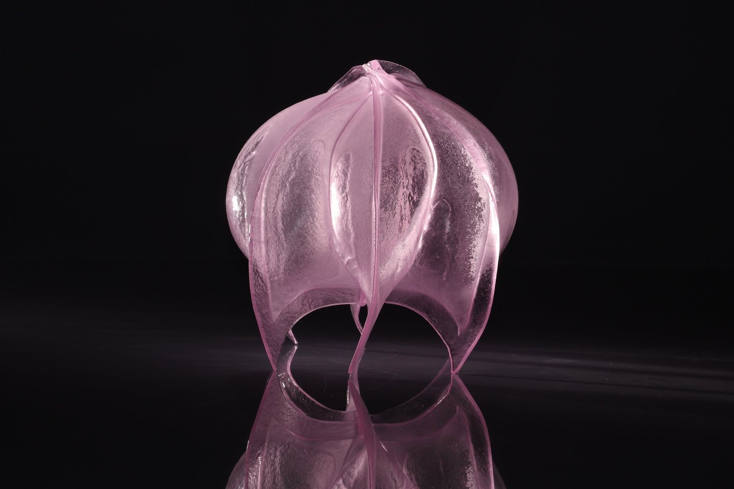 Een roze glazen kunstwerk van glaskunstenaar Linda van Huffelen van atelier Glasuniek.