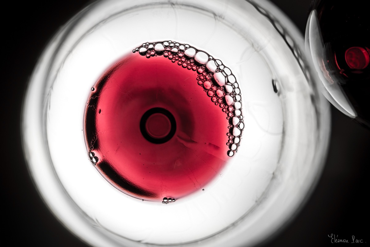 Vin rouge sombre en cercle parfait, cœur incandescent comme une étoile en fusion