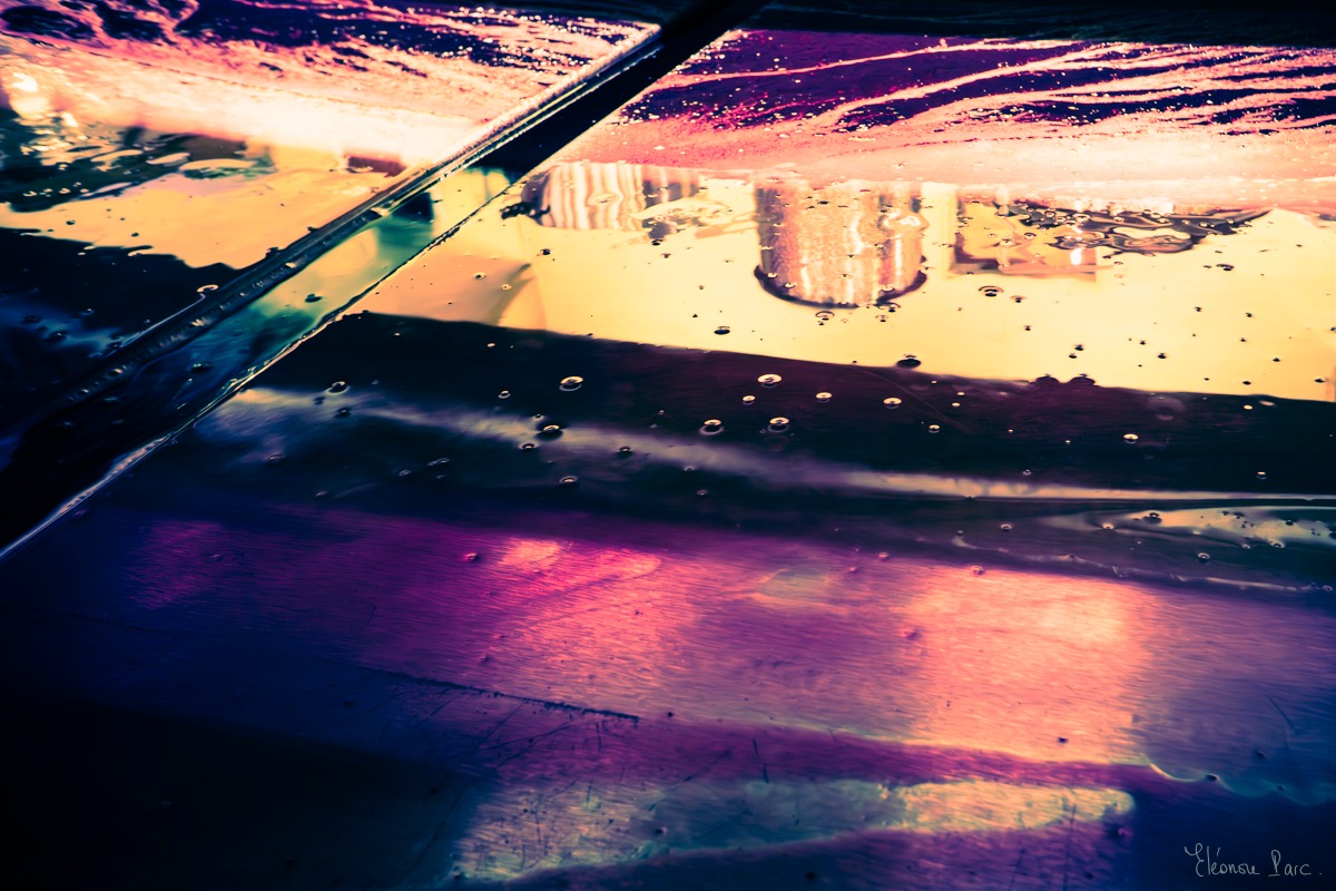 Écoulement du vin, surface irisée transformée en abstraction photographique.