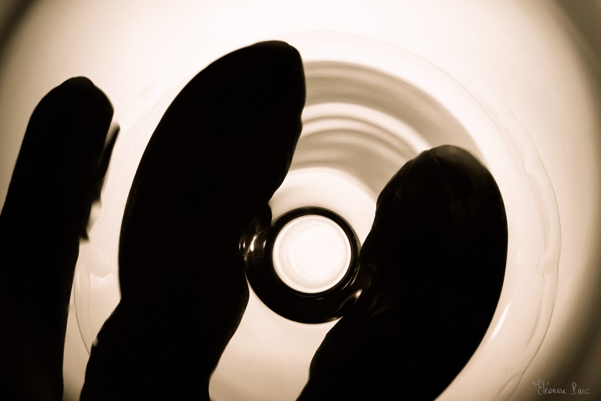 Vue du dessus d'un verre de vin blanc avec trois doigts déformés