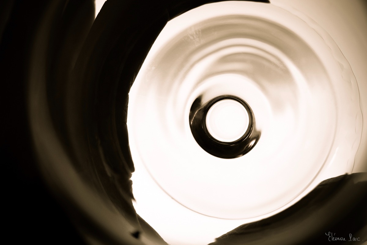 Cercle central d’un verre vu en plongée, ombres douces créant des formes fluides.
