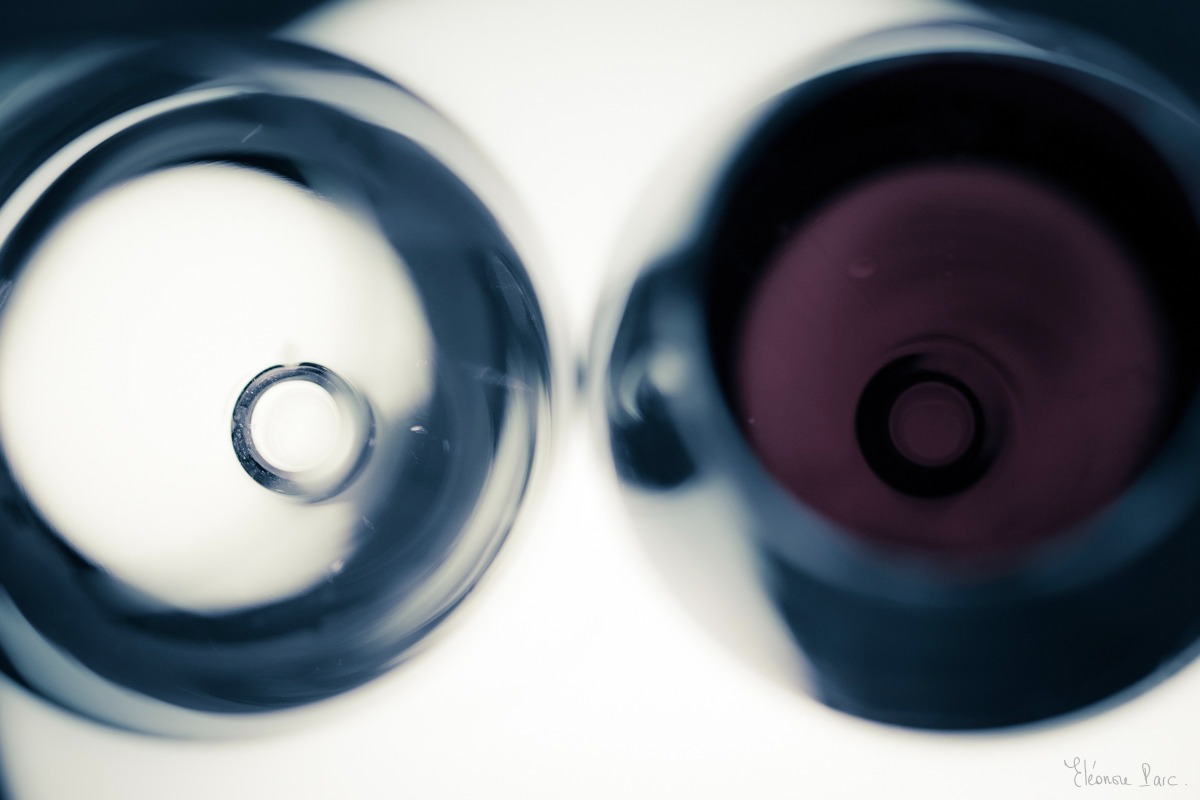 Vin Fantomatique – Deux verres vus du dessus, vin rouge à droite, verre clair à gauche