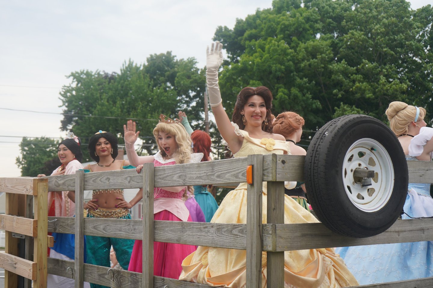 Princesses riding in a parade and waving