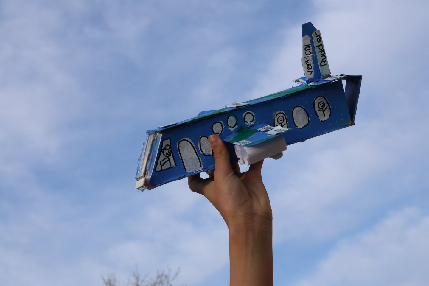 photo of Childs hand holding up cardboard airplane