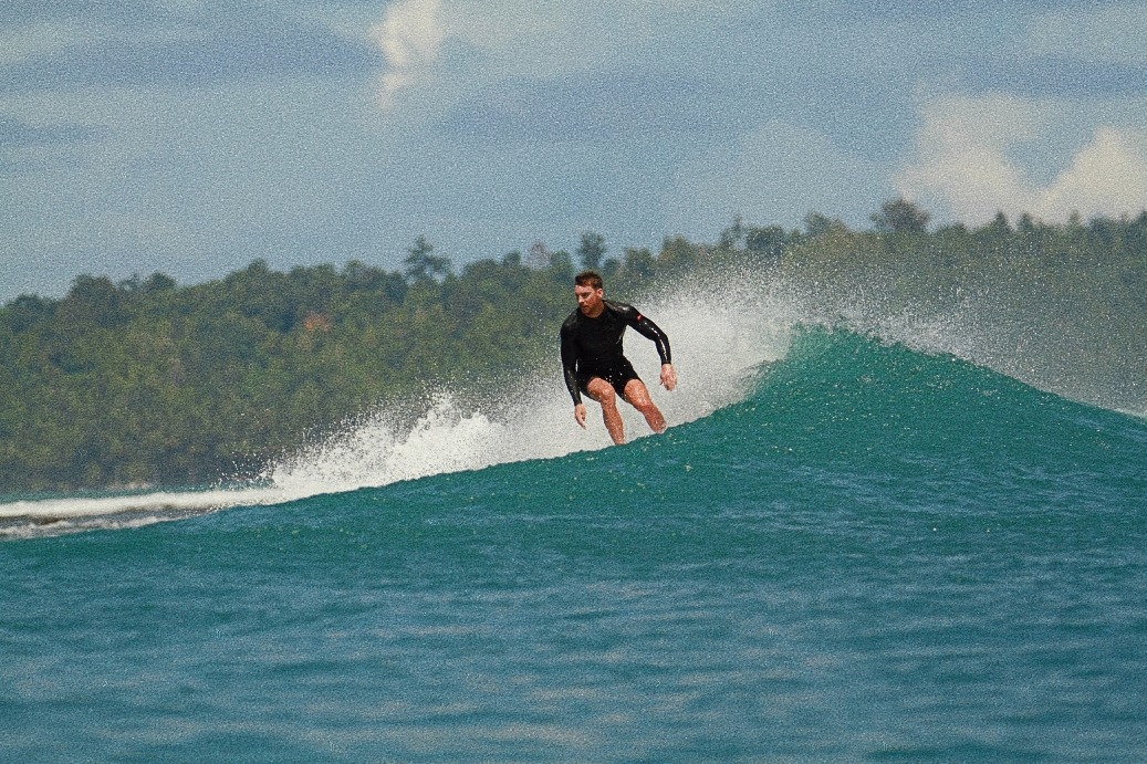 a man in a wetsuit surfing on a wave