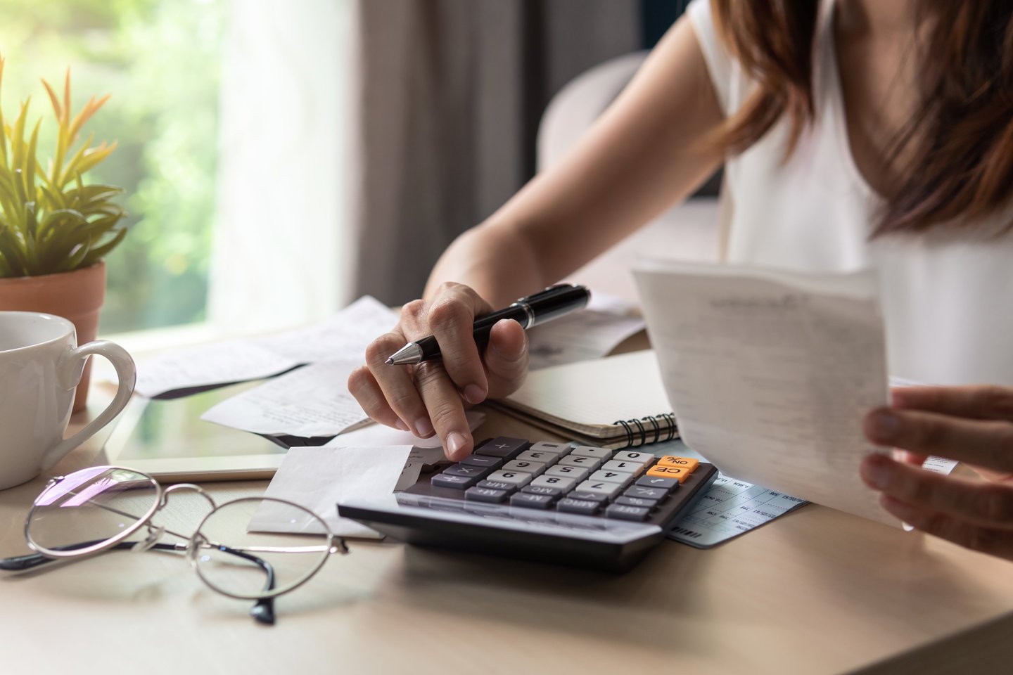 a woman is sitting at a desk with a calculator
