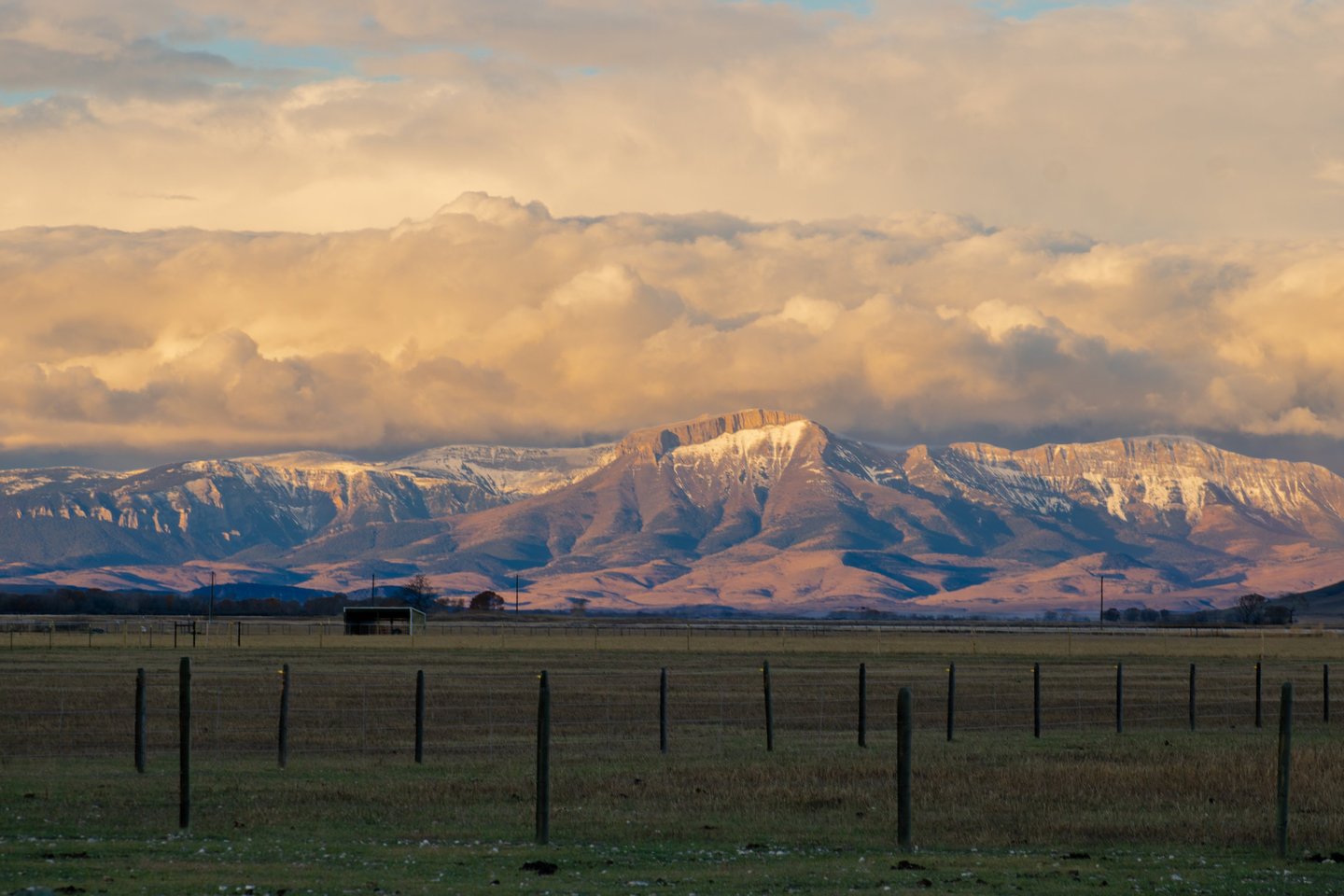 a large mountain range with a fenced in area, located in Montana, Teton Mountain Range