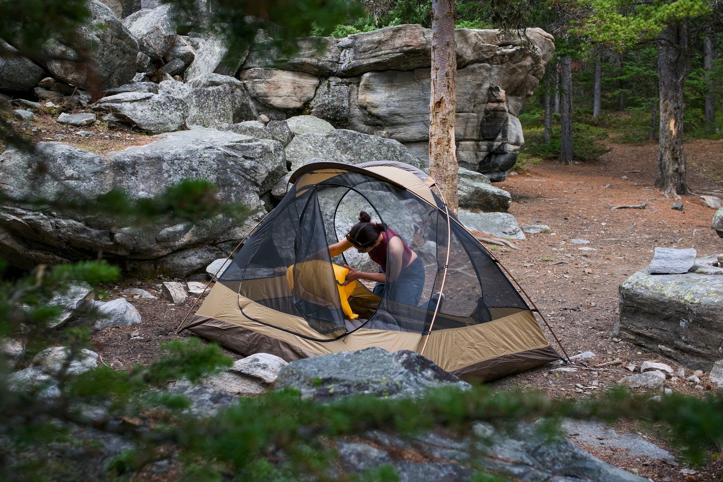 Woman getting a campsite ready by inflating sleeping pads