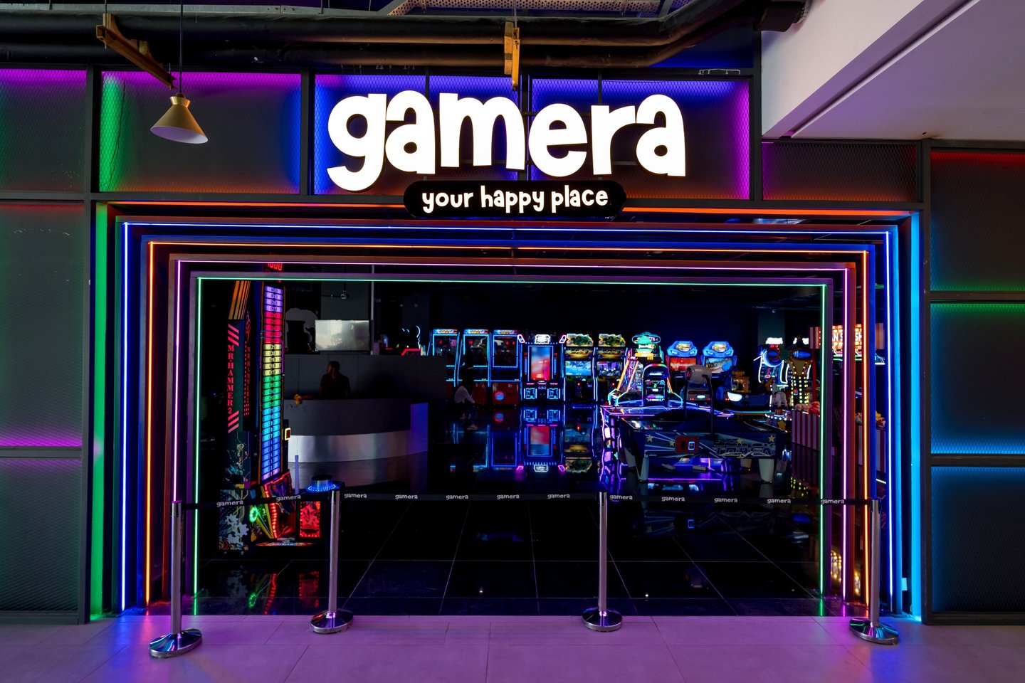 a storefront door with a neon - lit sign that says gamera