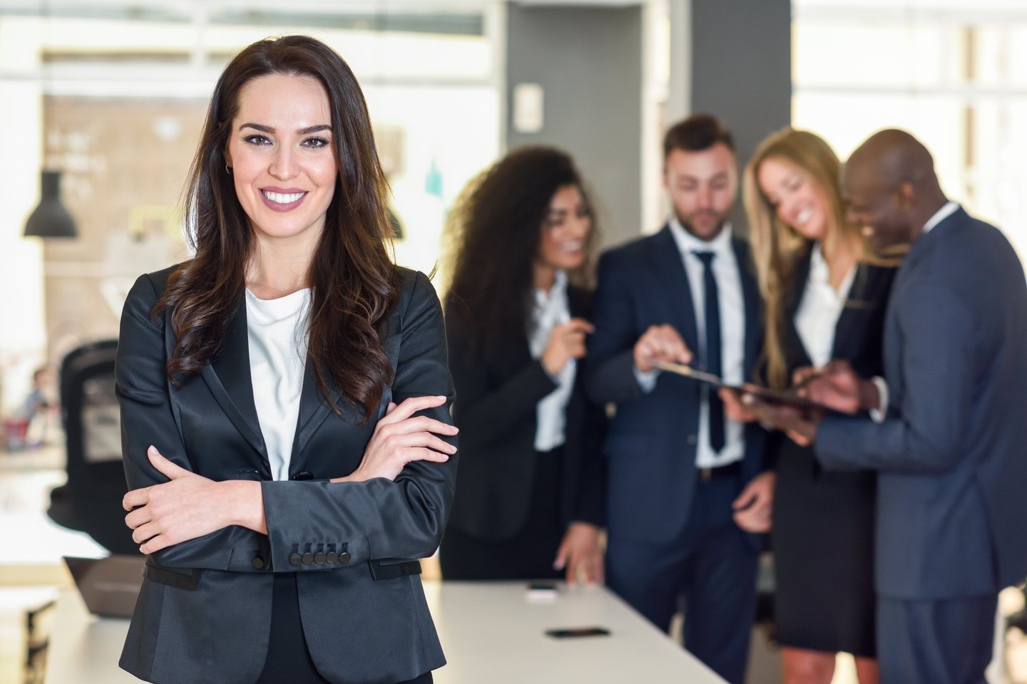 mujer en un traje parada al frente de un grupo de trabajo