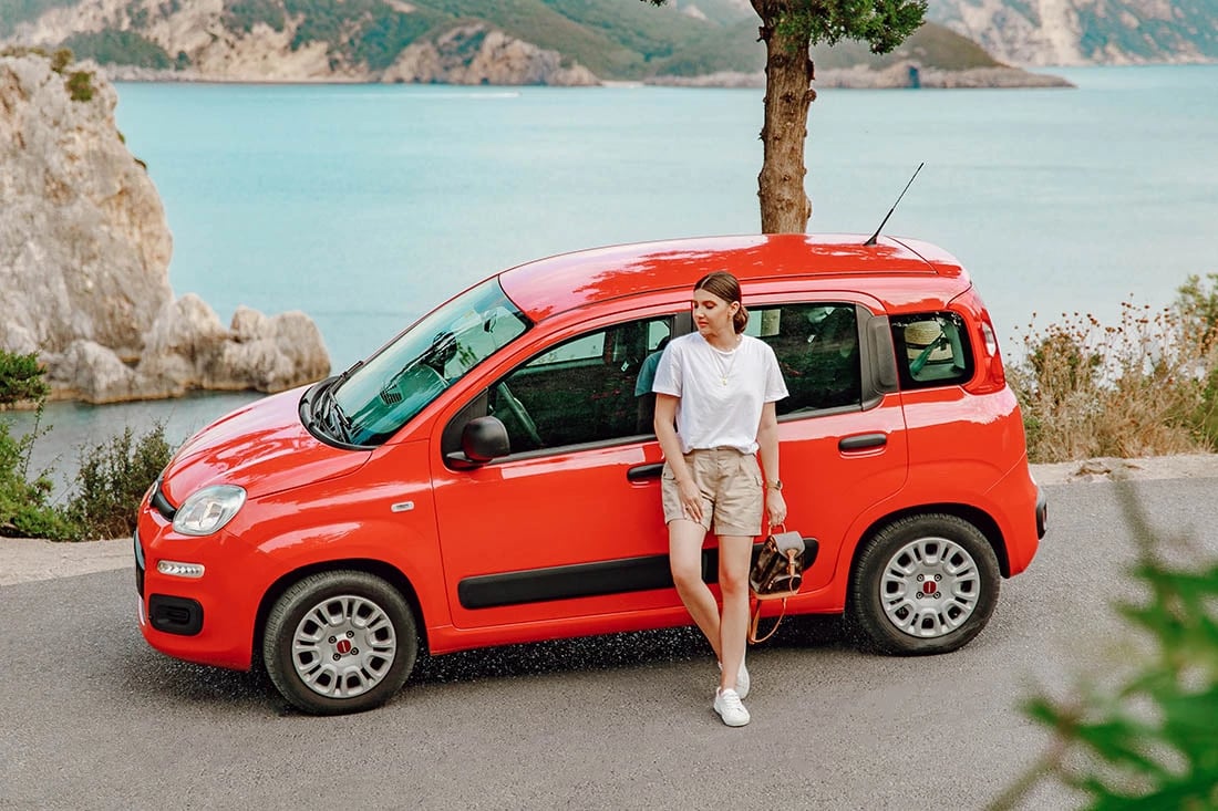 a woman standing next to a red van
