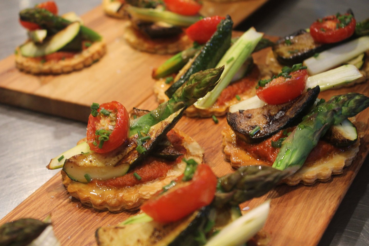 a wooden board with a variety of vegetables tart