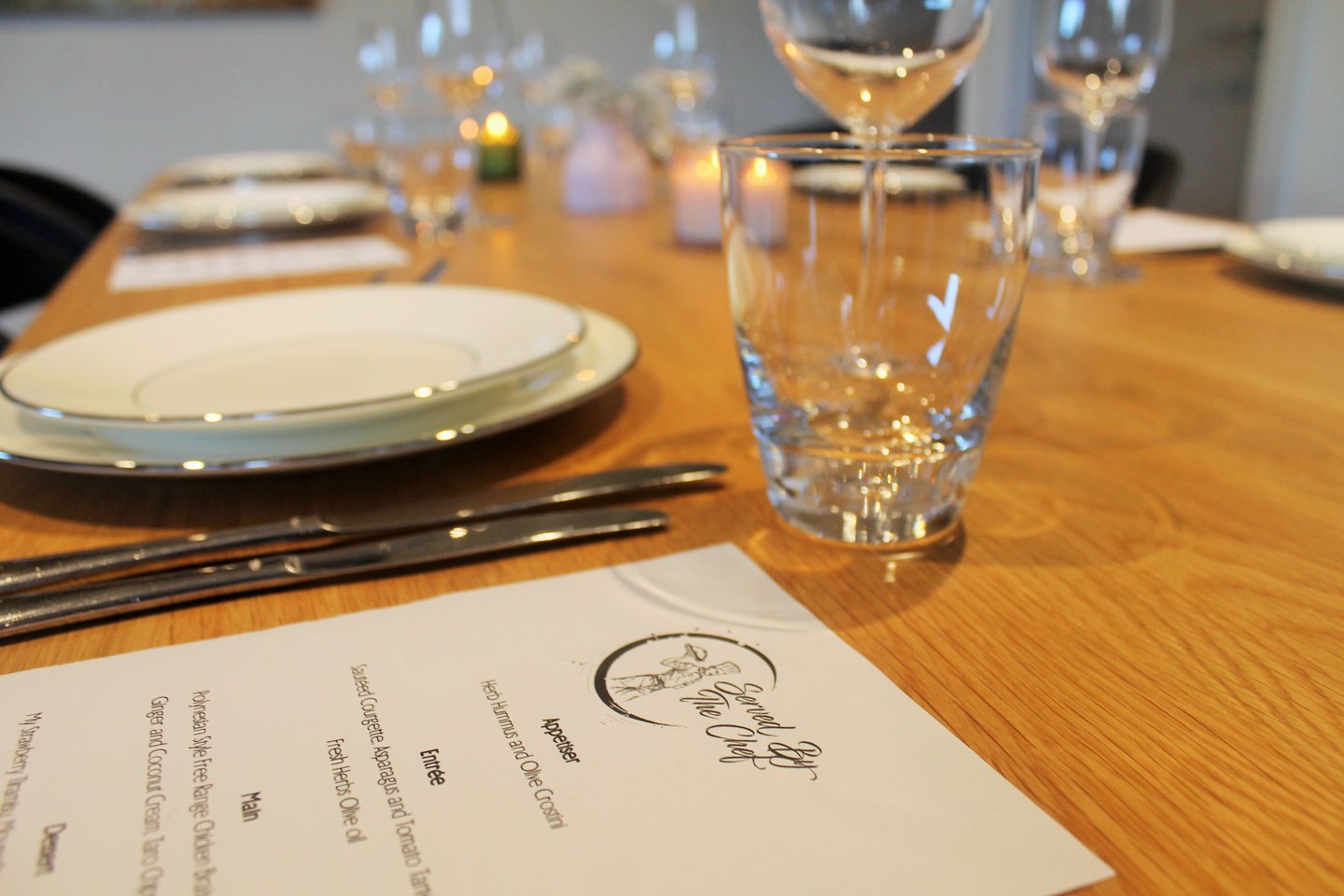a table with a menu card and wine glasses