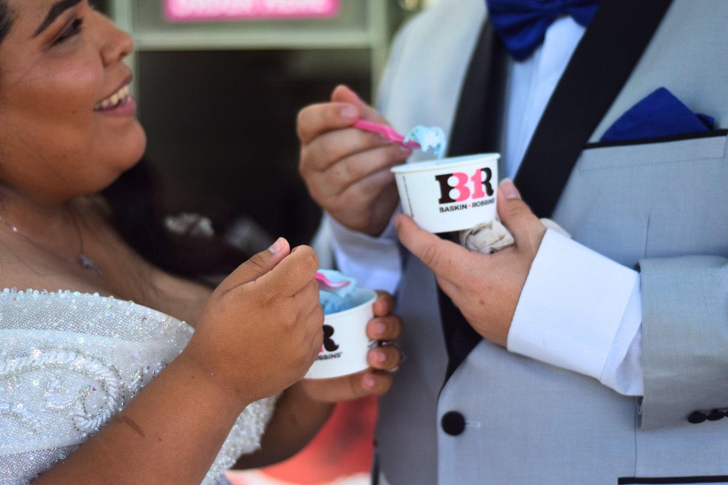 Close-up of smiling bride with groom holding ice cream during a Southern California wedding.