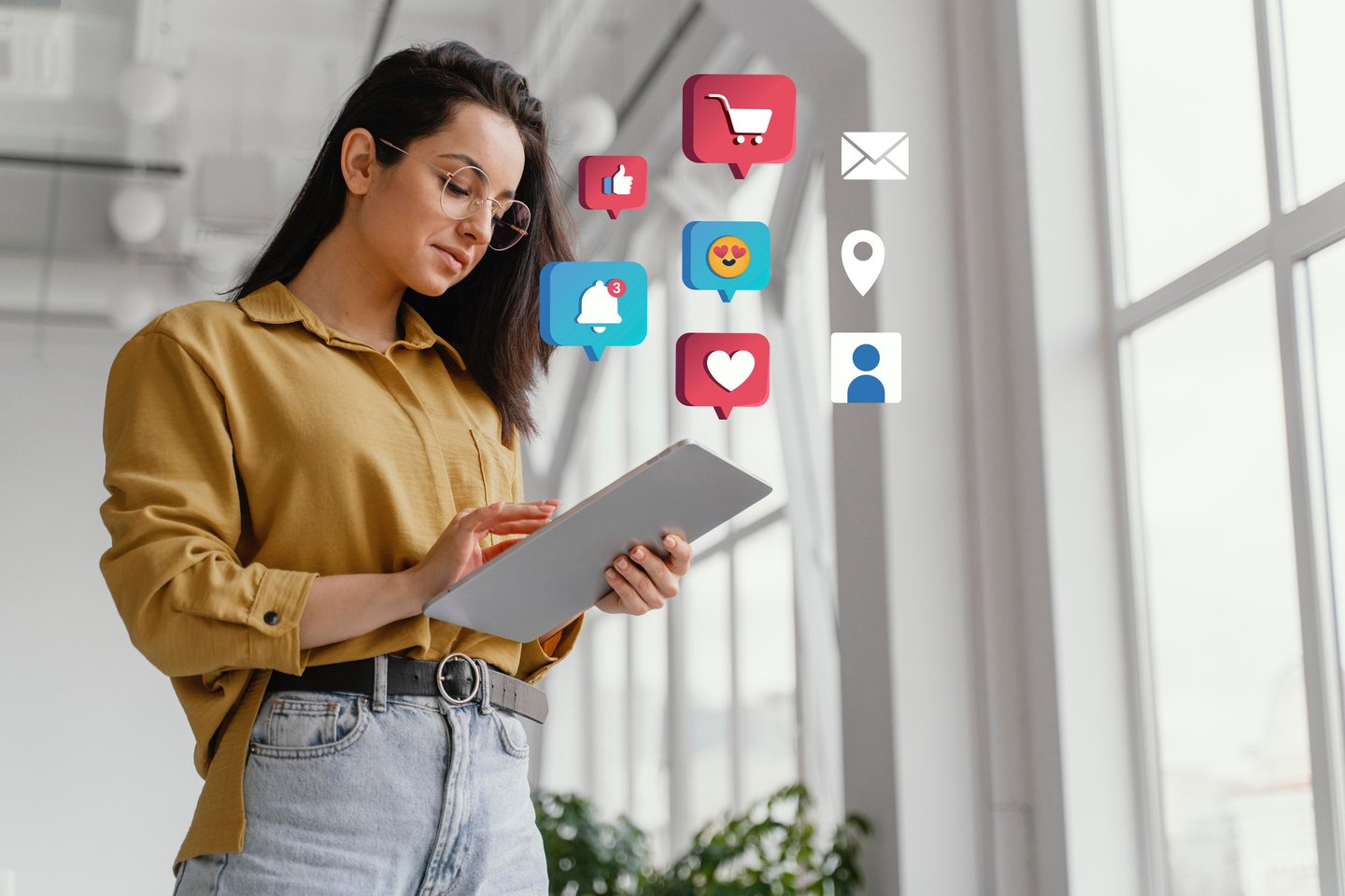 Una mujer sosteniendo una tablet en la que sobresalen likes, mails y notificaciones