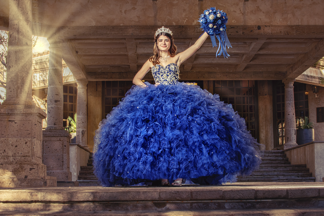 a woman in a blue dress with a bouquet in her hand