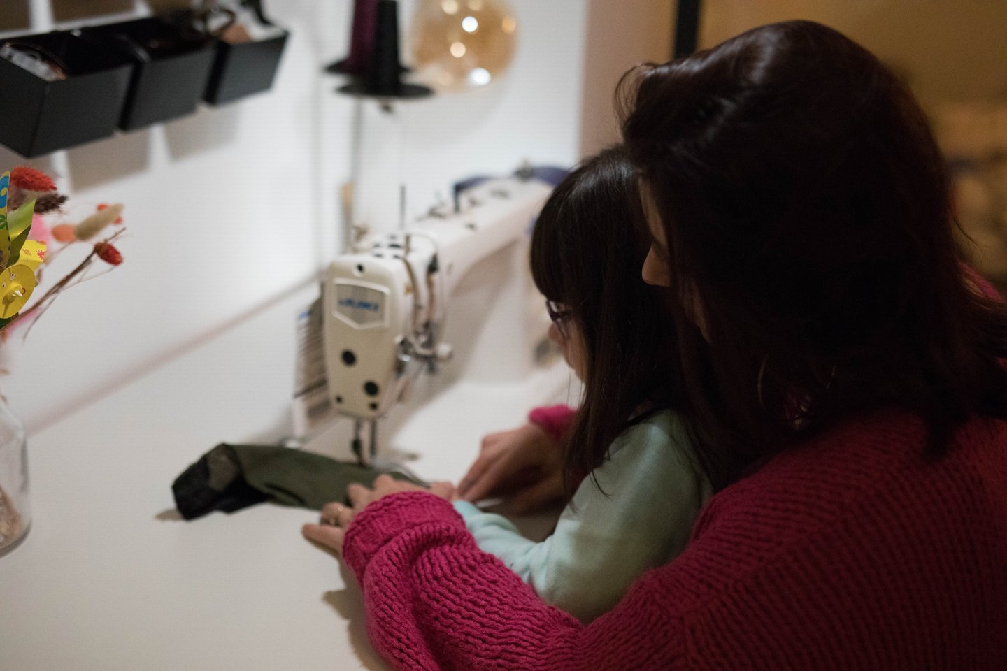 une femme et une petite fille sont en train de coudre un sac banane