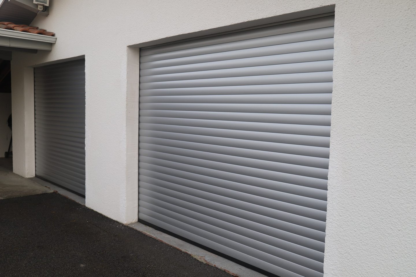 Porte de garage enroulante grise aluminium installé sur maison moderne par LB Menuiserie