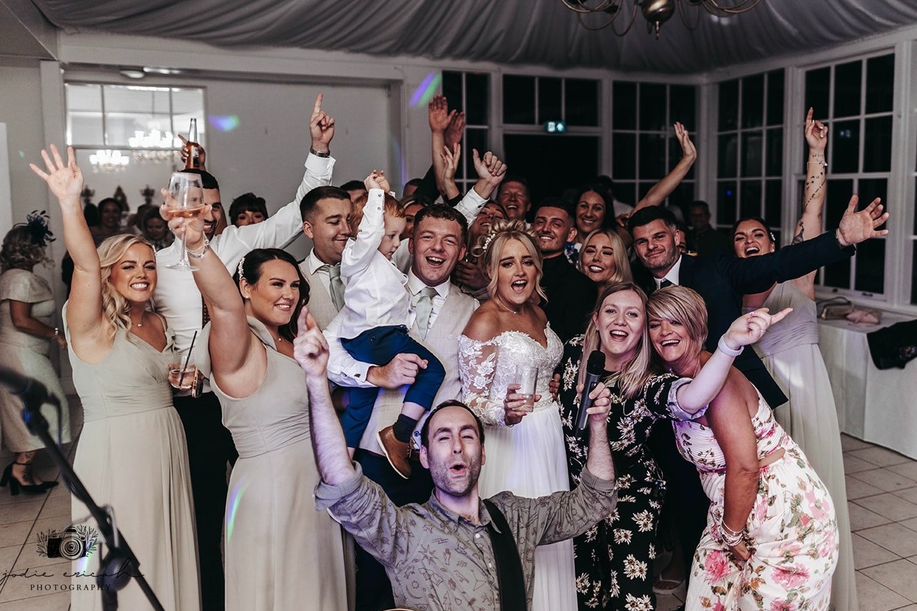 bride and group having fun with wedding singers and band