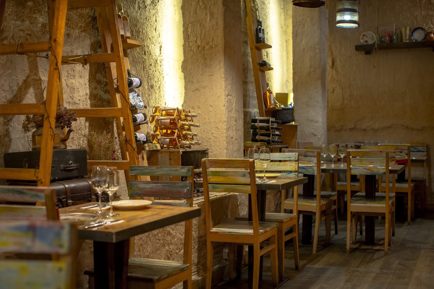 Rustic Tapastan restaurant interior with wooden tables, wine racks, and warm ambient lighting.