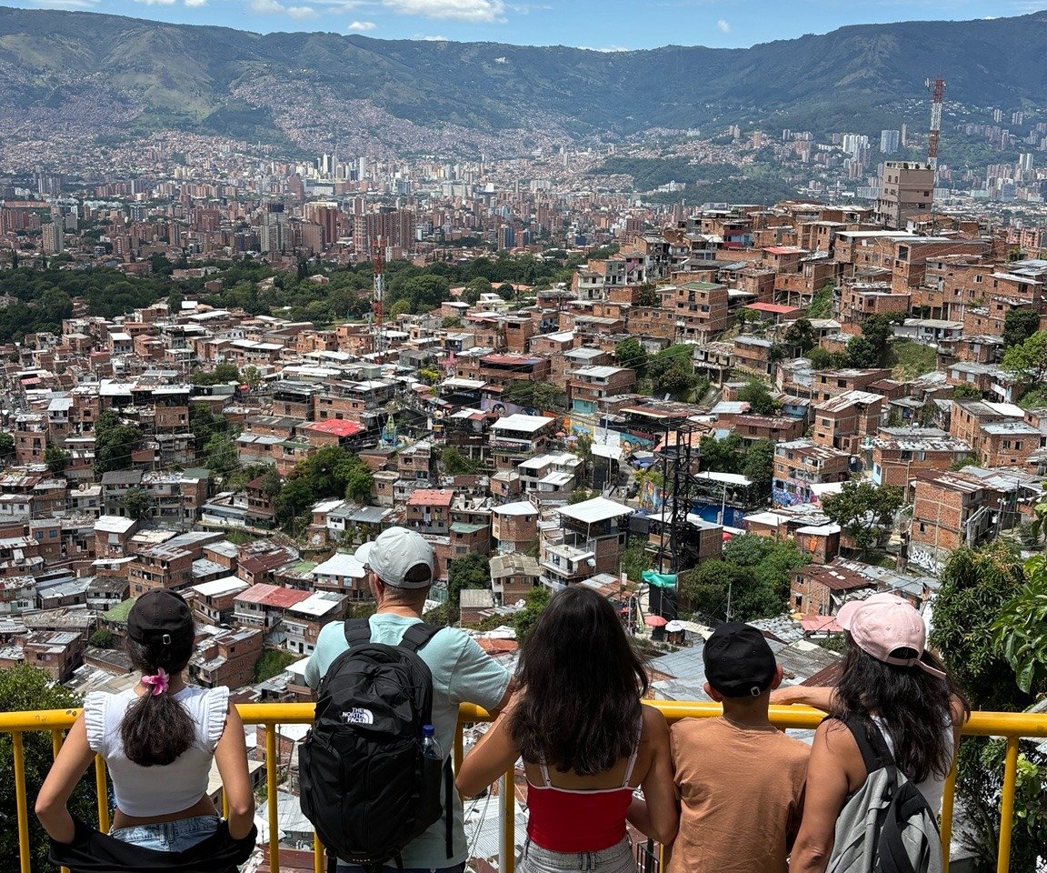 Vue panoramique sur la Comuna 3 à Medellín avec des voyageurs découvrant le quartier